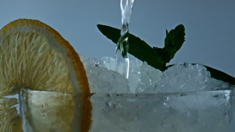Closeup-water-pouring-lemonade-drink.-Soda-filling-iced-citrus-mint-beverage