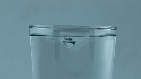 Closeup-aqua-tornado-inside-transparent-glass.-Beverage-whirlpool-clean-vessel