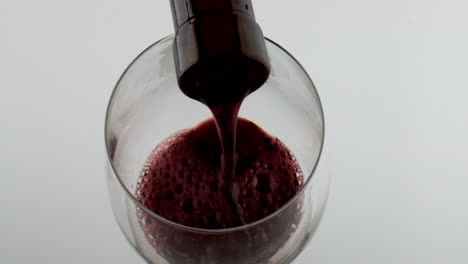 Bottle-filling-red-wine-goblet-closeup.-Cabernet-pouring-bubbling-in-wineglass