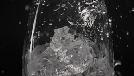 Spritzwasser-Gießt-Eisglas,-Nahaufnahme,-Zeitlupe.-Bio-Cocktail-Konzept