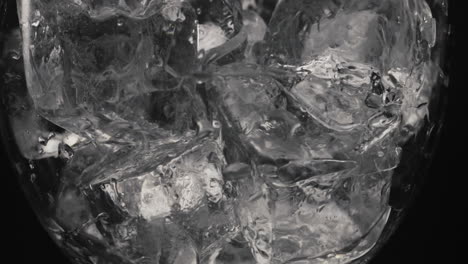 Ice-cubes-moving-empty-glass-closeup.-Refreshing-cocktails-making-concept