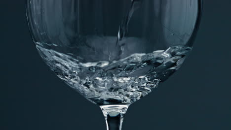 Nahaufnahme-Eines-Weinglases-Mit-Reinem-Wasser.-Luftblasen-Steigen-Vom-Boden-Der-Tasse-Auf