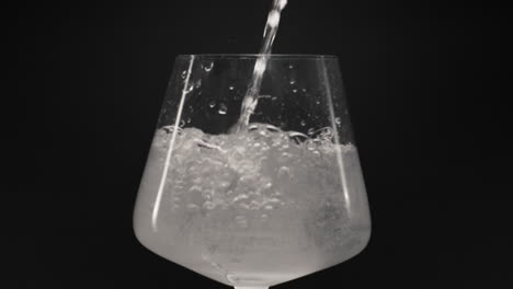 Sprudelwasser-Gießt-Eisglas,-Nahaufnahme,-Zeitlupe.-Bio-Cocktail-Konzept