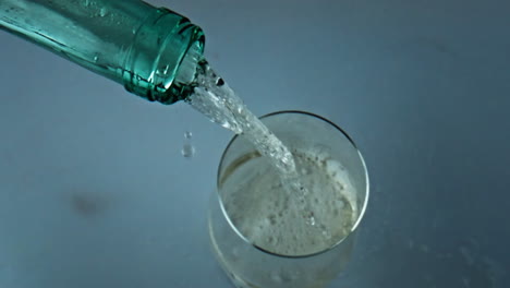 Transparent-bottle-pouring-wine-closeup.-White-alcohol-liquid-bubbling-in-glass.
