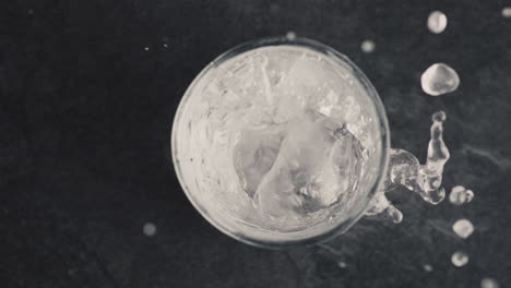Nahaufnahme-Eines-Glases-Mit-Perlendem-Eiswasser,-Draufsicht.-Konzept-Für-Erfrischende-Sommergetränke