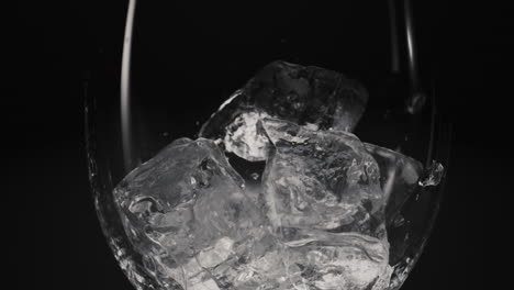 Frozen-blocks-falling-wineglass-closeup-slow-motion.-Thirst-quencher-concept