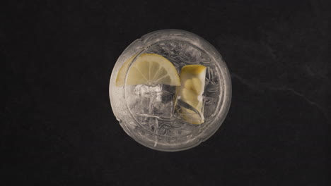 Hands-throw-mint-into-lemon-ice-drink-closeup.-Making-summer-cocktail-concept