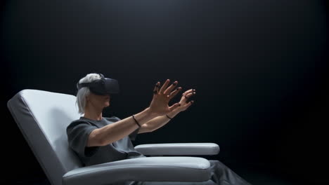 Amazed-guy-sensor-gloves-sitting-armchair.-Future-device-man-watching-3d-movie