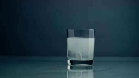 Tablette-Löst-Sich-Im-Wasserglas-Auf-Dunklem-Hintergrund,-Nahaufnahme.-Behandlung-Mit-Säuretabletten