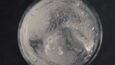Closeup-hands-throw-ice-cube-into-glass-with-fizzy-water.-Make-cocktail-concept