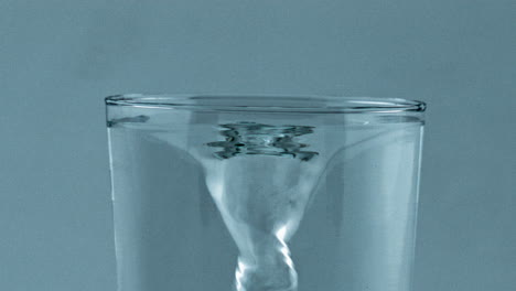 Spinning-fresh-water-vessel-closeup.-Transparent-aqua-created-funnel-glassware