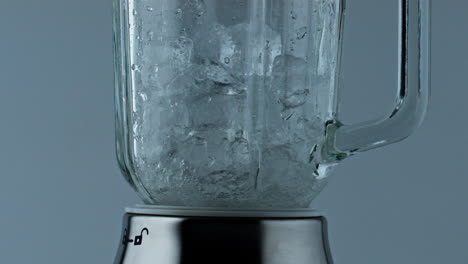Blender-crushing-ice-pieces-closeup.-Cocktail-mixer-grinding-cubes-for-beverage