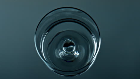 Water-droplet-falling-cup-top-view.-Pure-liquid-waving-rippling-in-transparent
