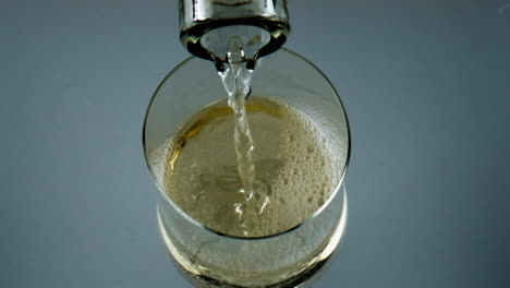 Closeup-bottle-pouring-white-wine-into-goblet.-Fizzy-drink-bubbling-in-glass.