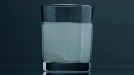 Sprudelndes-Medizinwasserglas-Auf-Dunklem-Hintergrund,-Nahaufnahme.-Saure-Luftblasen-Steigen-Auf