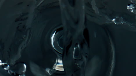 Closeup-water-splashing-glass-top-view.-Pure-refreshing-liquid-pouring-cup.