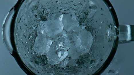 Closeup-blender-crushing-ice-top-view.-Iced-cubes-grinding-in-mixer-container.