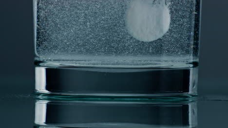 Effervescent-tablet-water-dissolving-closeup.-Fizzy-white-pill-flowing-rising