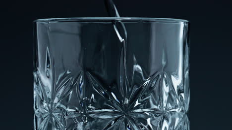 Nahaufnahme-Eines-Glases-Wasser-Mit-Spritzendem-Dunklem-Hintergrund.-Kristallklare,-Frische-Flüssigkeit