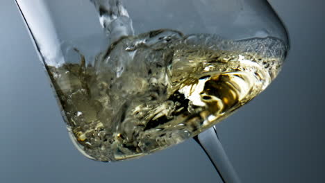 Closeup-bubbling-wine-filling-beautiful-goblet.-Diverse-air-bubbles-rise-liquid