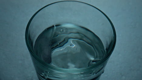 Tablet-dropping-glass-top-view-closeup.-Pure-water-splashing-in-transparent-cup.