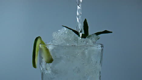 Wasser-Gießt-Eisgekühlten-Cocktail-In-Glas,-Nahaufnahme.-Erfrischendes-Klassisches-Sommergetränk