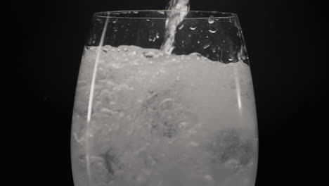 Schäumendes-Wasser-Gießt-Eisweinglas,-Nahaufnahme.-Cocktail-Konzept-Vorbereiten