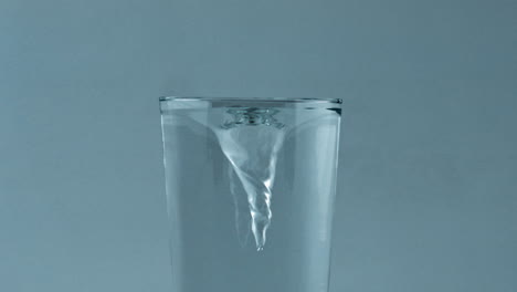 Klarer-Kaltwasserwirbel-Im-Glasbehälter,-Nahaufnahme.-Eiscocktail-Dreht-Sich