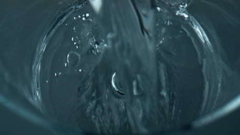 Closeup-water-stream-pouring-empty-glass.-Mineral-pure-liquid-fill-transparent
