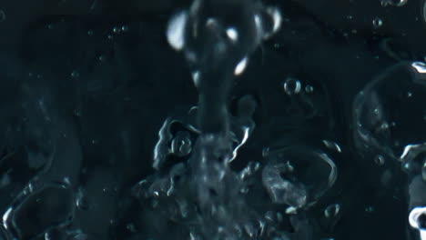 Closeup-pure-liquid-filling-transparent-cup-top-view.-Droplets-falling-rippling