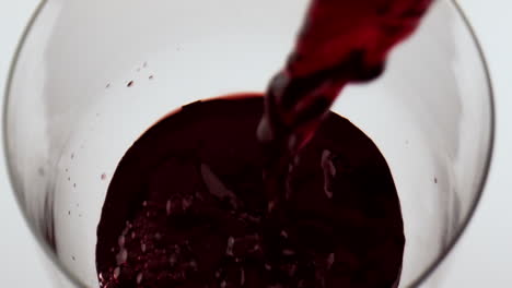 Red-wine-pouring-glass-closeup.-Beautiful-merlot-bubbling-splashing-in-goblet