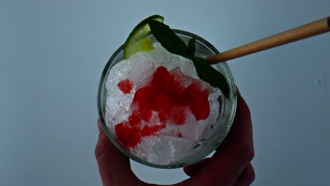 Hand-taking-cocktail-glass-closeup.-Overhead-shot-bartender-holding-iced-mojito