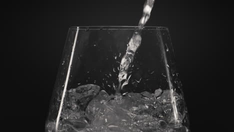 Ice-water-pouring-wineglass-closeup.-Preparing-refreshing-cocktail-concept