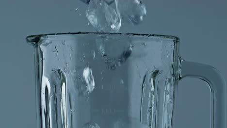 Closeup-ice-filling-blender-cup.-Making-refreshing-beverage-in-cocktail-mixer.