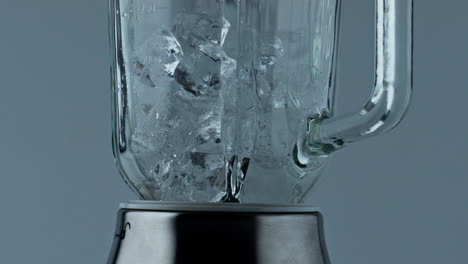 Ice-cubes-falling-blender-container-closeup.-Grinder-machine-filling-with-iced