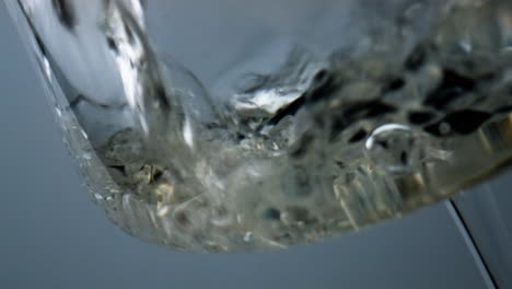 Closeup-white-wine-bubbling-splashing-in-goblet.-Air-bubbles-flowing-liquid.