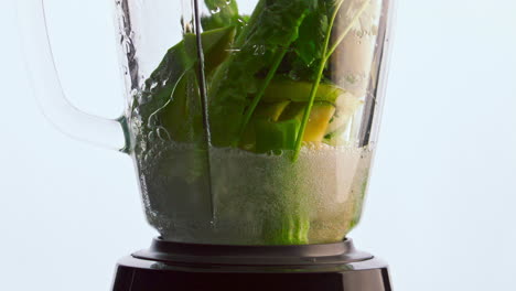Closeup-blender-vegetables-poured-water-in-super-slow-motion.-Healthy-nutrition.