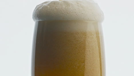 Craft-beverage-pouring-transparent-glass-closeup.-Stream-making-foam-drink