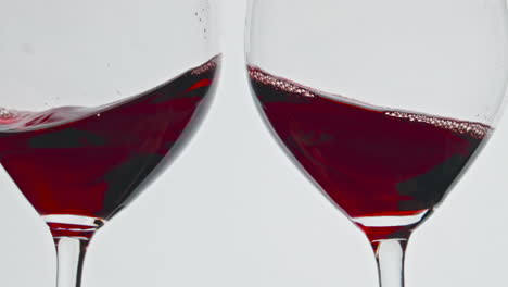 Cheering-red-wine-glasses-closeup.-Alcohol-rose-drink-clinking-toasting-goblets