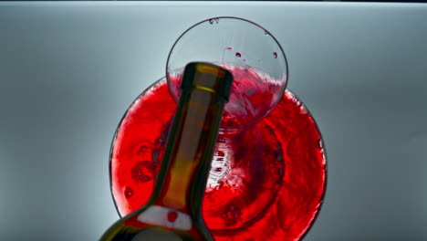 Red-wine-stream-pouring-glassware-from-bottle.-Alcohol-beverage-filling-decanter