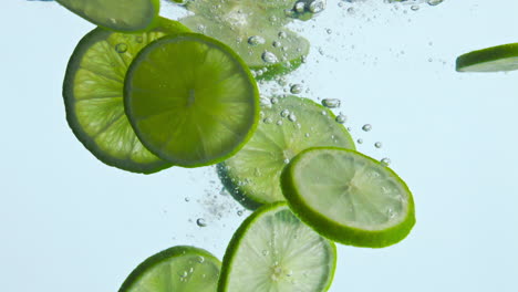 Tropical-sliced-lime-dropped-water-in-white-background-closeup.-Citrus-splashing