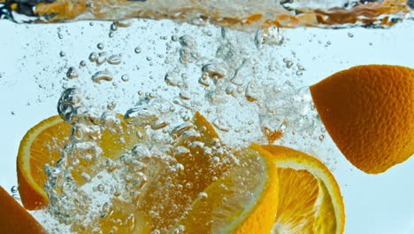 Orangenschnitze-Spritzen-In-Super-Zeitlupe,-Nahaufnahme,-Im-Wasser.-Zitrusfrüchte-Unter-Wasser.