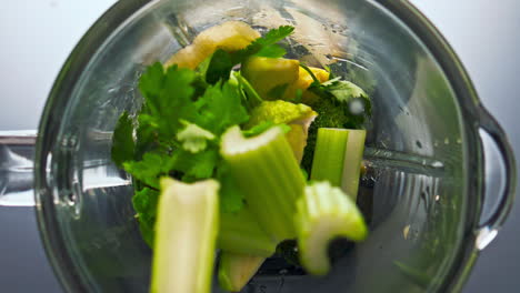 Raw-green-vegetable-falling-blender-in-super-slow-motion-close-up.-Vitamin-food.