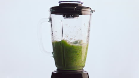 Blending-green-vegetable-smoothie-in-mixer-close-up.-Preparing-vitamin-cocktail.