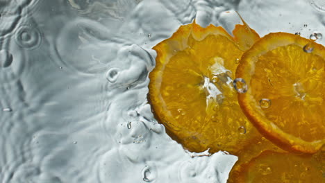 Tropische-Orangenscheiben,-Die-In-Wasser-Spritzen,-Nahaufnahme.-Zitrusstücke-Fallen-Gesund