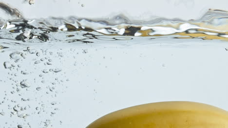 Closeup-banana-splashing-water-container.-Organic-exotic-fruit-floating-in-light