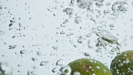 Beautiful-limes-splash-water-in-light-background-closeup.-Tropical-fruits-drop