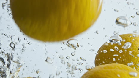 Limones-Orgánicos-Que-Caen-Agua-En-Primer-Plano-De-Burbujas.-Hermosos-Cítricos-Frescos-Cayendo