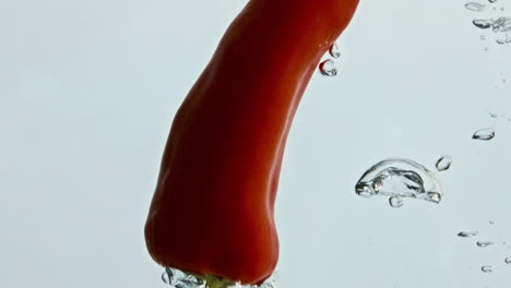 Rote-Chilischoten-Spritzen-In-Wasser,-Nahaufnahme.-Würziges-Gemüse,-Das-In-Die-Spüle-Fließt