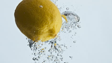 Zitronenfrucht,-Fallendes-Wasser-In-Blasen,-Nahaufnahme.-Sommerfrische-Zitrusfrüchte-Steigen-An-Die-Oberfläche